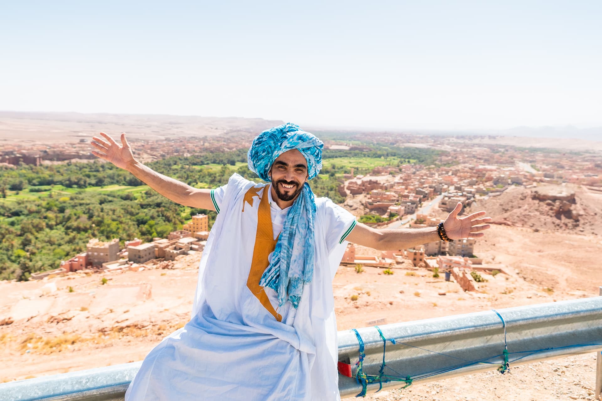 ASHAMRAHE ABDESSAMAD, founder of Trips Morocco Sahara, in traditional Moroccan attire overlooking a valley