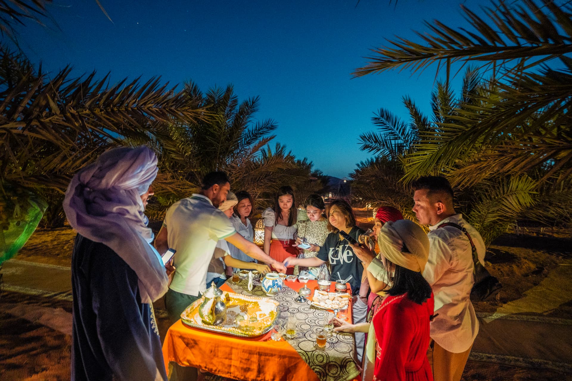 Travellers sharing evening tea in a palm grove